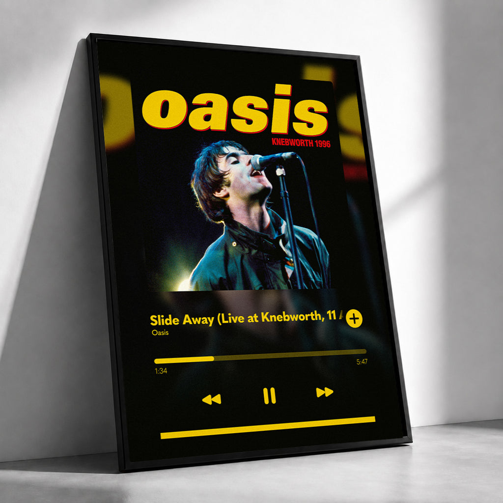 A framed Oasis 'Slide Away' music player-style poster leaning against a white wall on a light floor. The artwork shows the band name 'oasis' in large yellow letters above a photo of a performer at a microphone, with album text and playback controls on a black background.