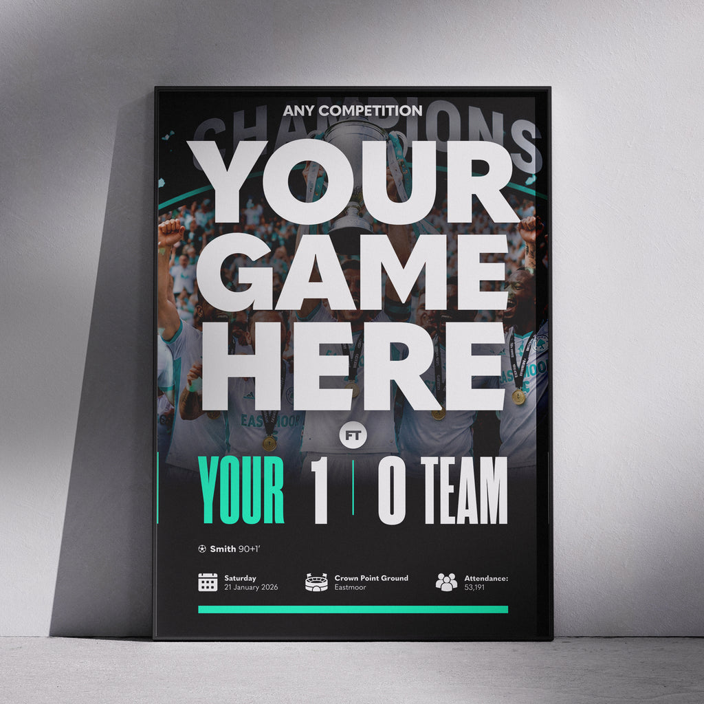 A framed sports event poster mockup leaning against a gray wall on a concrete floor. The poster features a black background with a blurred crowd photo, large white text reading 'YOUR GAME HERE', and teal accents including 'YOUR 1 0 TEAM'.